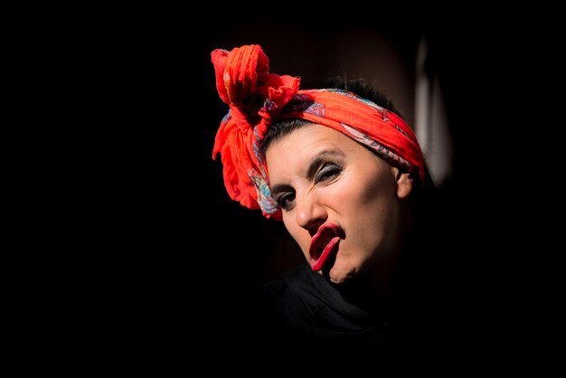 young latin woman gesticulating with her mouth, colorful scarf on her head