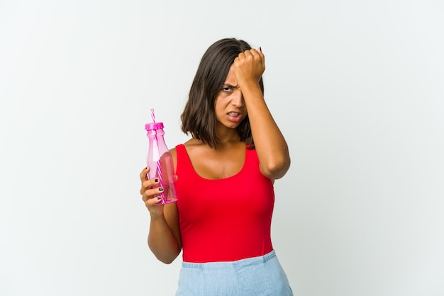 Young latin woman holding a milkshake isolated on white background forgetting something, slapping forehead with palm and closing eyes.