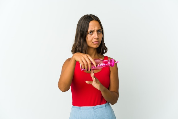 Young latin woman holding a milkshake isolated on white wall showing a timeout gesture.