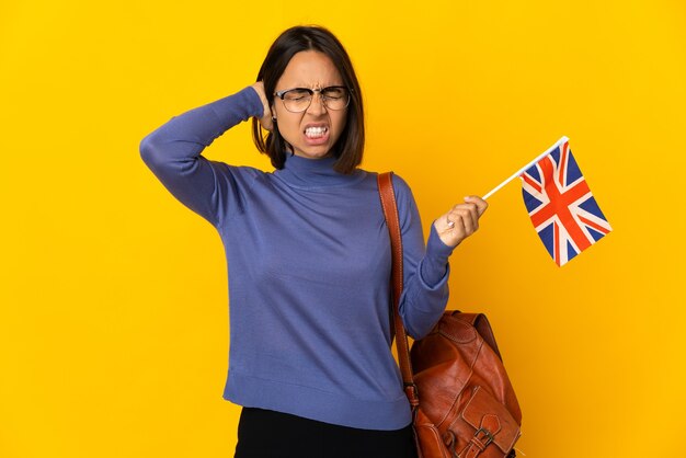 Young latin woman holding an United Kingdom flag isolated