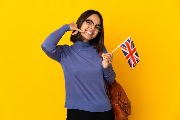 Young latin woman holding an United Kingdom flag isolated