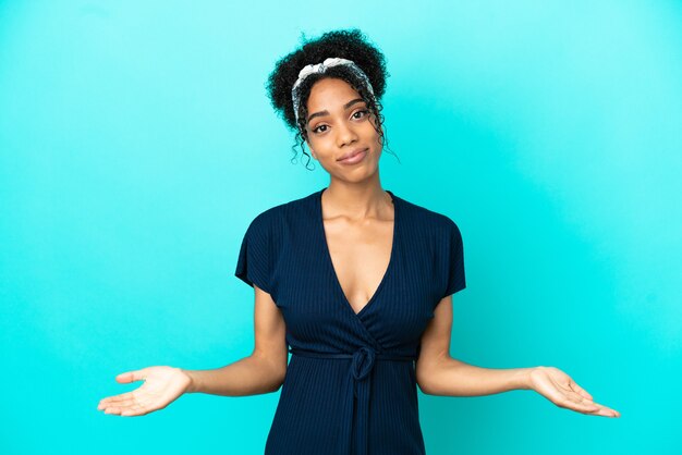 Young latin woman isolated on blue background having doubts