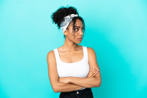 Young latin woman isolated on blue background keeping the arms crossed