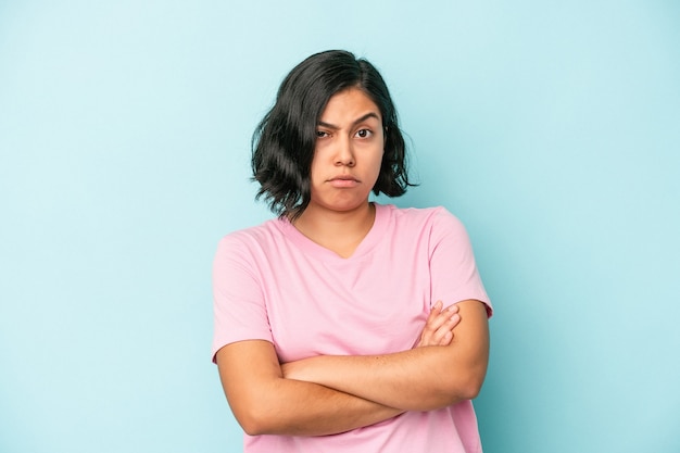 Young latin woman isolated on blue background unhappy looking in camera with sarcastic expression.