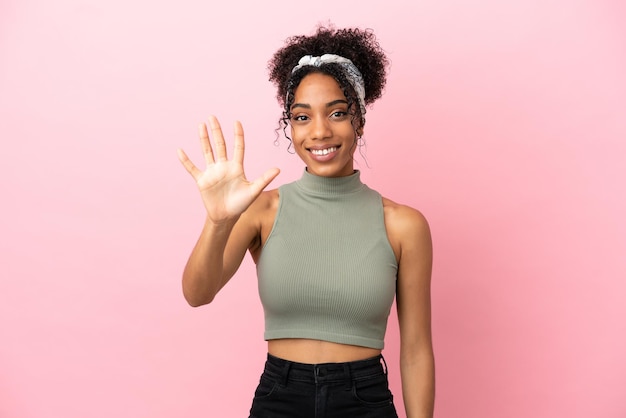 Young latin woman isolated on pink background counting five with fingers