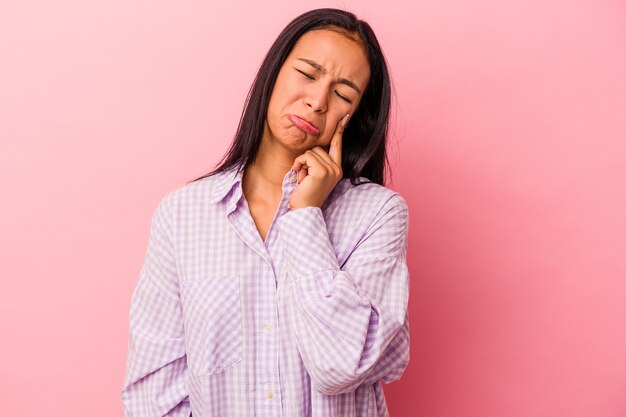 Young latin woman isolated on pink background  crying, unhappy with something, agony and confusion concept.