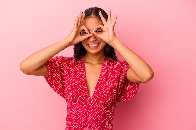 Young latin woman isolated on pink background  excited keeping ok gesture on eye.