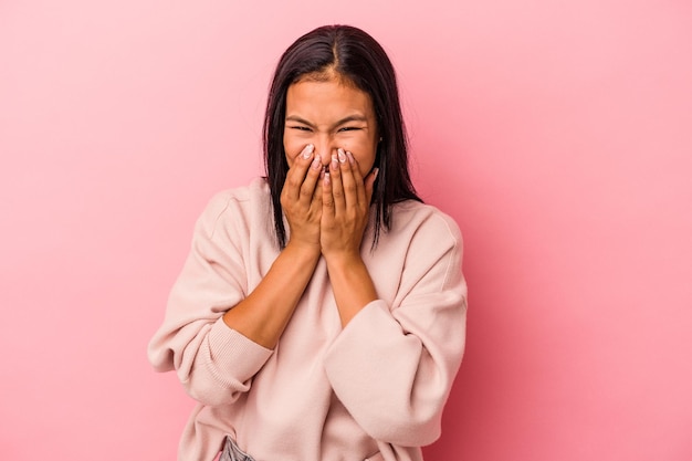 Young latin woman isolated on pink background  laughing about something covering mouth with hands