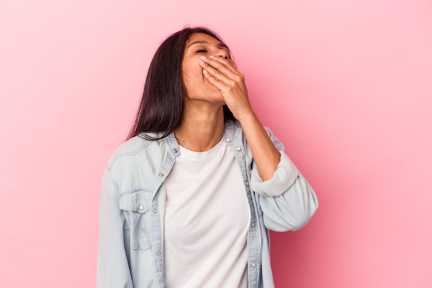 Young latin woman isolated on pink background laughing happy, carefree, natural emotion.