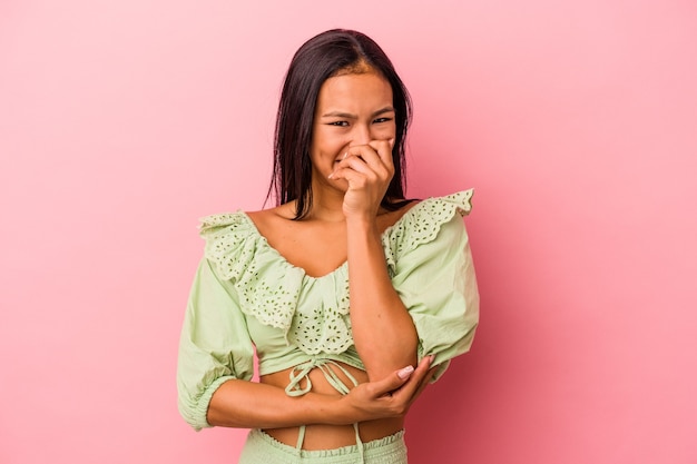 Young latin woman isolated on pink background  laughing happy, carefree, natural emotion.
