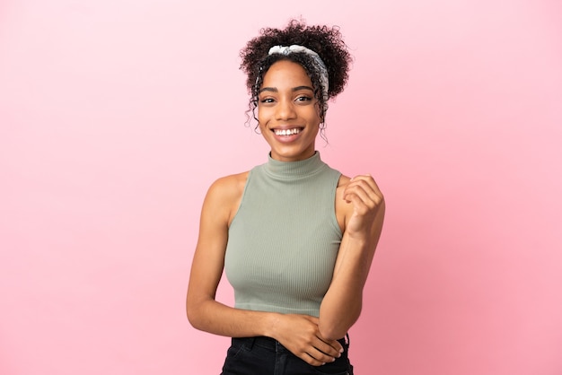 Young latin woman isolated on pink background laughing