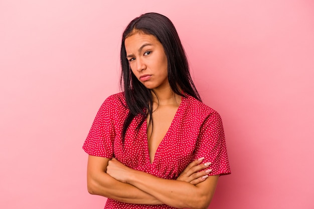 Young latin woman isolated on pink background  tired of a repetitive task.