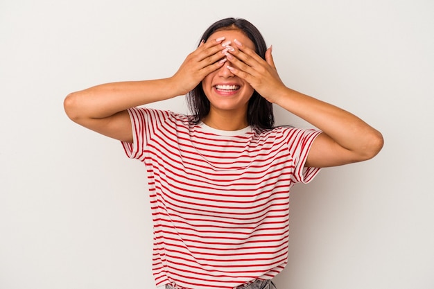 Young latin woman isolated on white background  covers eyes with hands, smiles broadly waiting for a surprise.