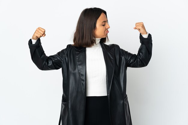 Young latin woman isolated on white background doing strong gesture