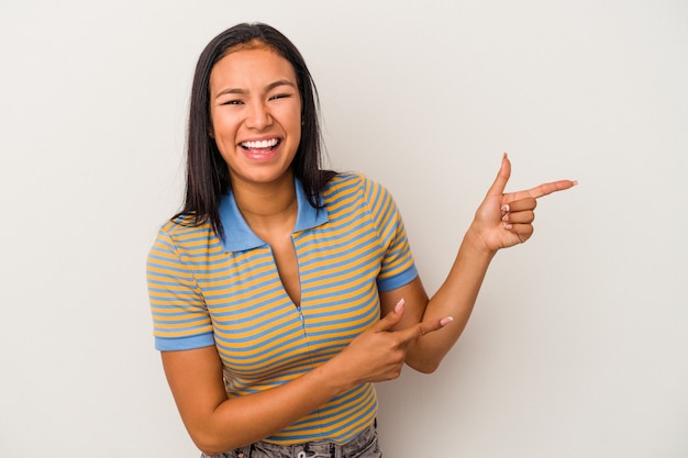 Young latin woman isolated on white background  excited pointing with forefingers away.