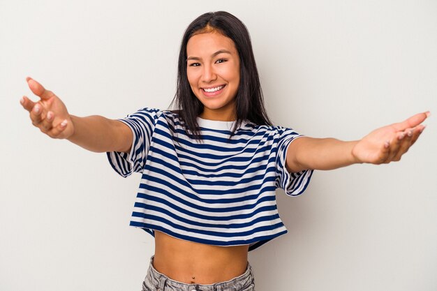 Young latin woman isolated on white background  feels confident giving a hug to the camera.