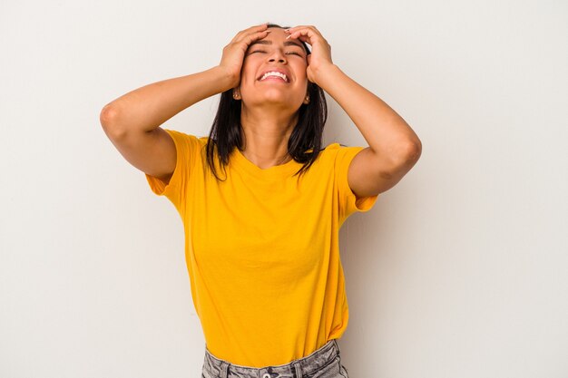 Young latin woman isolated on white background  laughs joyfully keeping hands on head. Happiness concept.