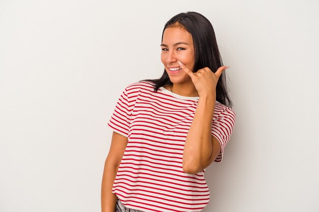 Young latin woman isolated on white background  showing a mobile phone call gesture with fingers.