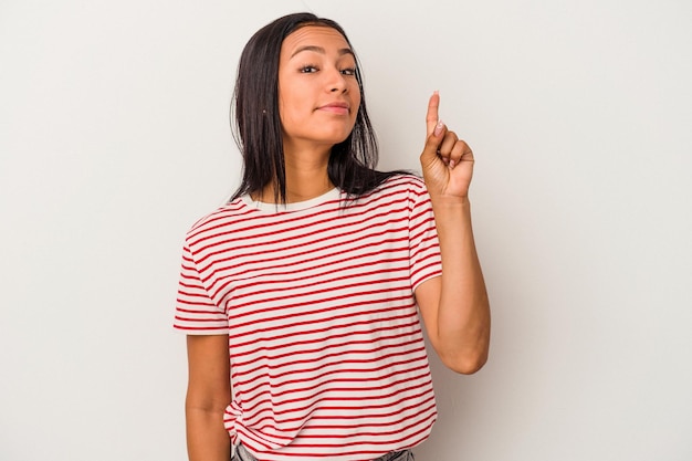 Young latin woman isolated on white background  showing number one with finger