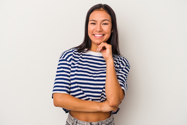 Young latin woman isolated on white background  smiling happy and confident, touching chin with hand.