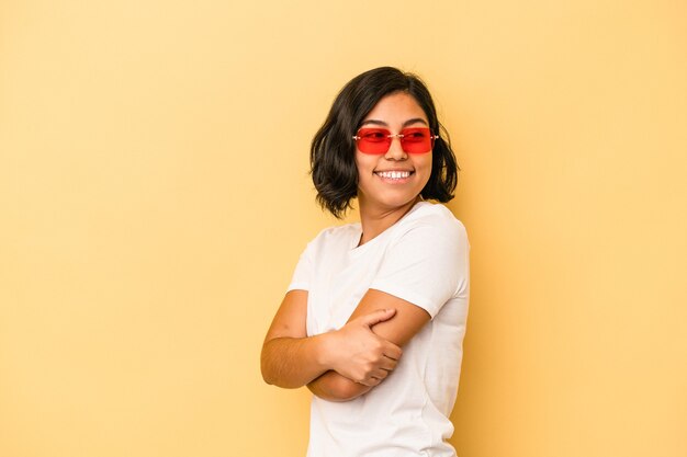 Young latin woman isolated on yellow background laughing and having fun.