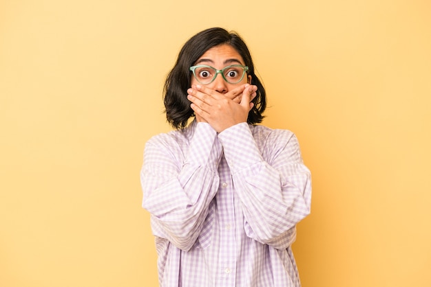 Young latin woman isolated on yellow background shocked covering mouth with hands.