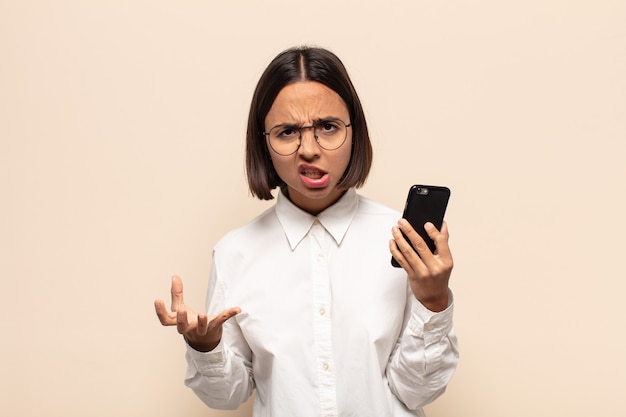 Young latin woman looking angry, annoyed and frustrated