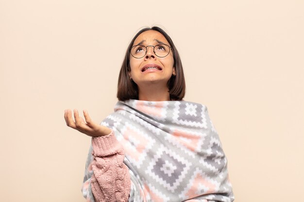 Young latin woman looking desperate and frustrated, stressed, unhappy and annoyed, shouting and screaming