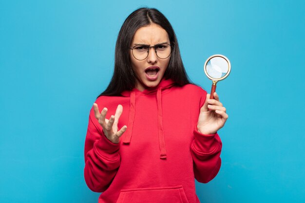 Young latin woman looking desperate and frustrated, stressed, unhappy and annoyed, shouting and screaming