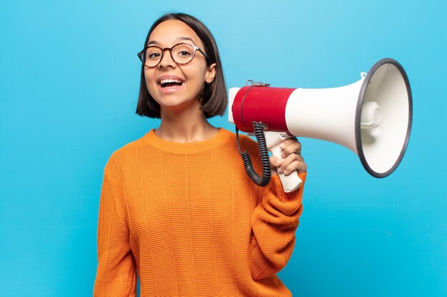 魅了され、ショックを受けた表情で興奮し、幸せで嬉しい驚きに見える若いラテン女性