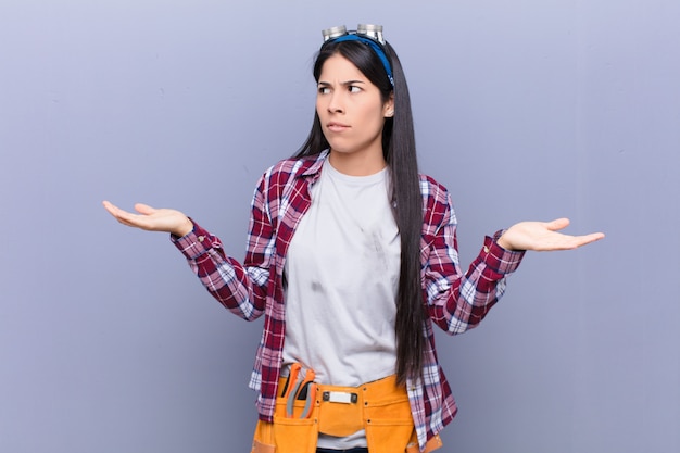 Young latin woman looking puzzled, confused and stressed, wondering between different options, feeling uncertain