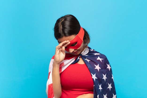 Young latin woman looking stressed, tired and frustrated, drying sweat off forehead, feeling hopeless and exhausted