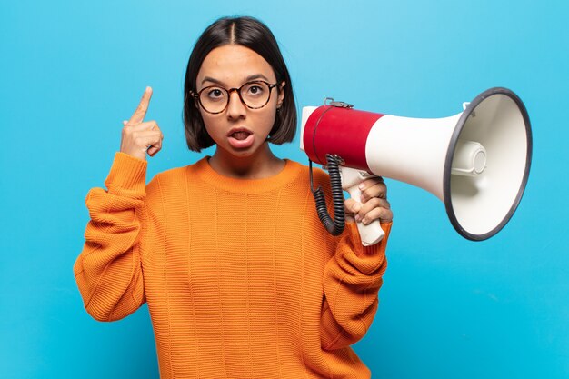 Young latin woman looking surprised, open-mouthed, shocked, realizing a new thought, idea or concept