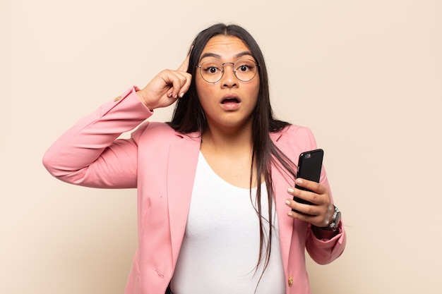 Young latin woman looking surprised, open-mouthed, shocked, realizing a new thought, idea or concept