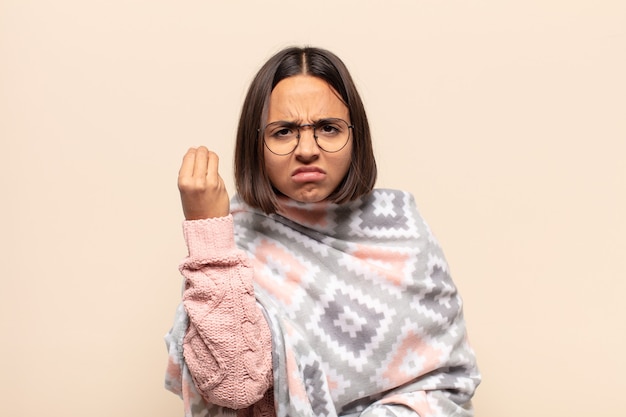 Young latin woman making capice or money gesture, telling you to pay your debts!