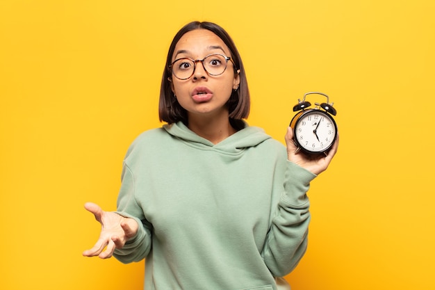 Young latin woman open-mouthed and amazed, shocked and astonished with an unbelievable surprise