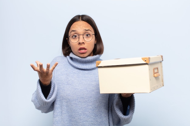 Young latin woman open-mouthed and amazed, shocked and astonished with an unbelievable surprise