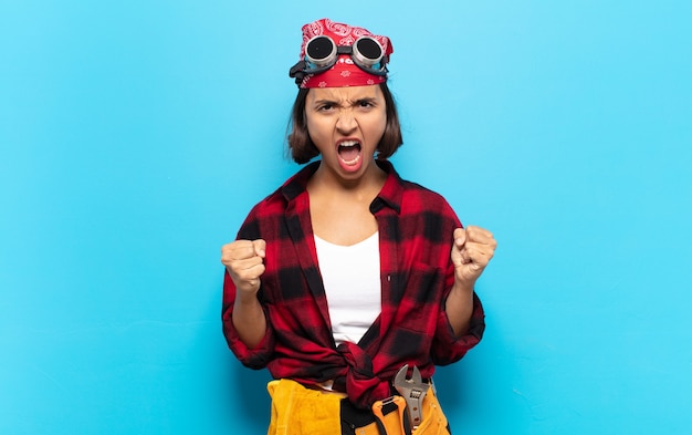 Young latin woman shouting aggressively with annoyed