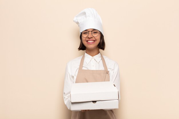 Young latin woman smiling happily with friendly, confident, positive look, offering and showing an object or concept