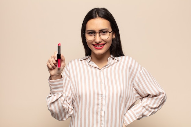 Young latin woman smiling happily with a hand on hip and confident, positive, proud and friendly attitude