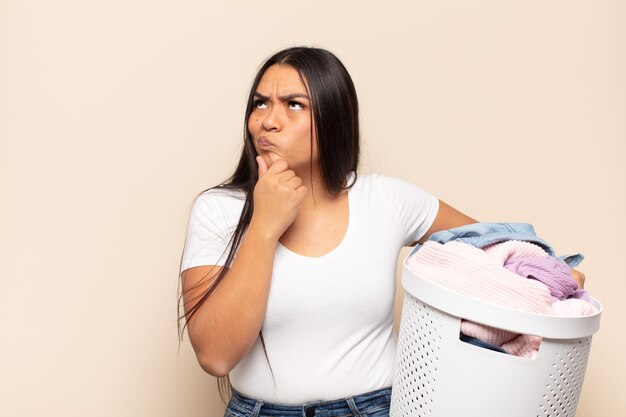 Young latin woman thinking, feeling doubtful and confused, with different options, wondering which decision to make