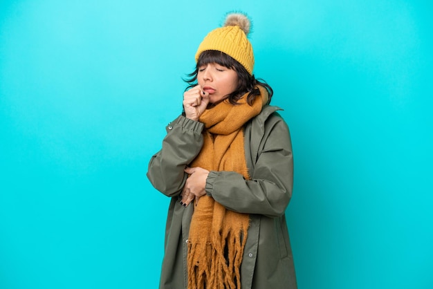 Young latin woman wearing winter jacket isolated on blue background