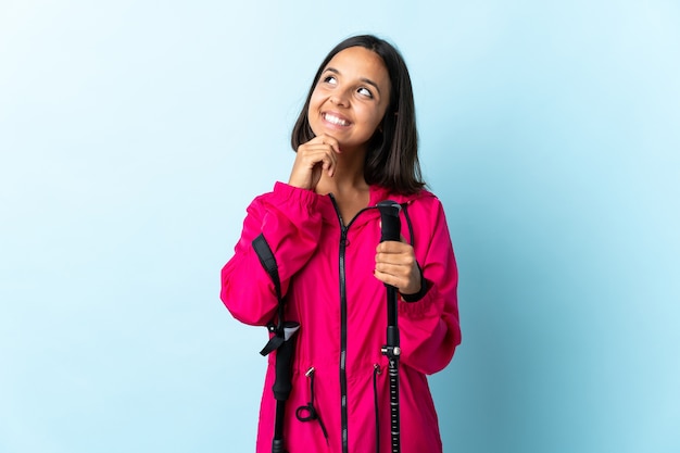 Young latin woman with backpack and trekking poles