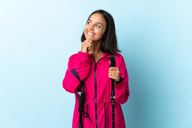 Young latin woman with backpack and trekking poles