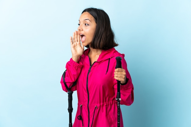 Young latin woman with backpack and trekking poles