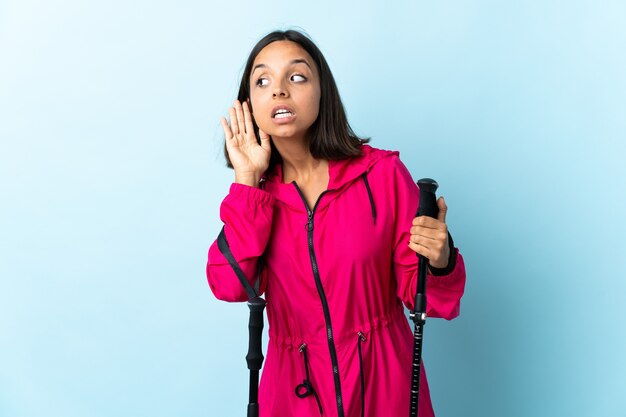 Young latin woman with backpack and trekking poles