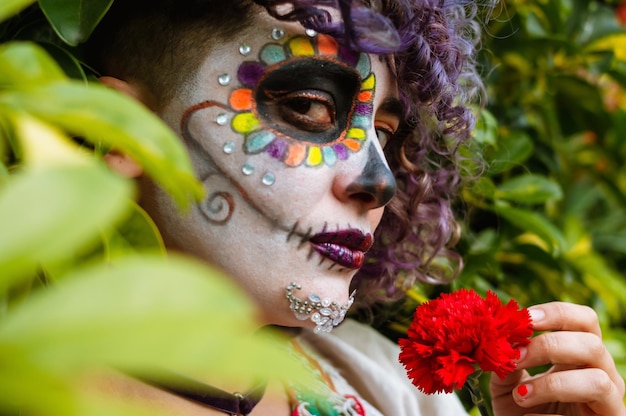 Молодая латиноамериканка с макияжем катрина смотрит в камеру в профиль