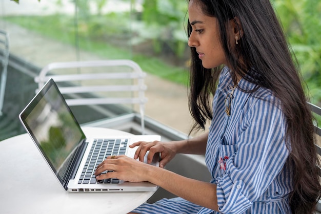 Young latin woman with her laptop in a cafe terrace, Panama, Central America