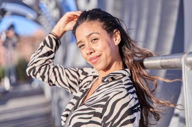 young latina looking at the camera touching her hair with her hand