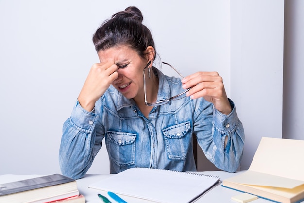 Young latina woman taking off her glasses because her eyes hurt presbyopia eyesight eye doctor